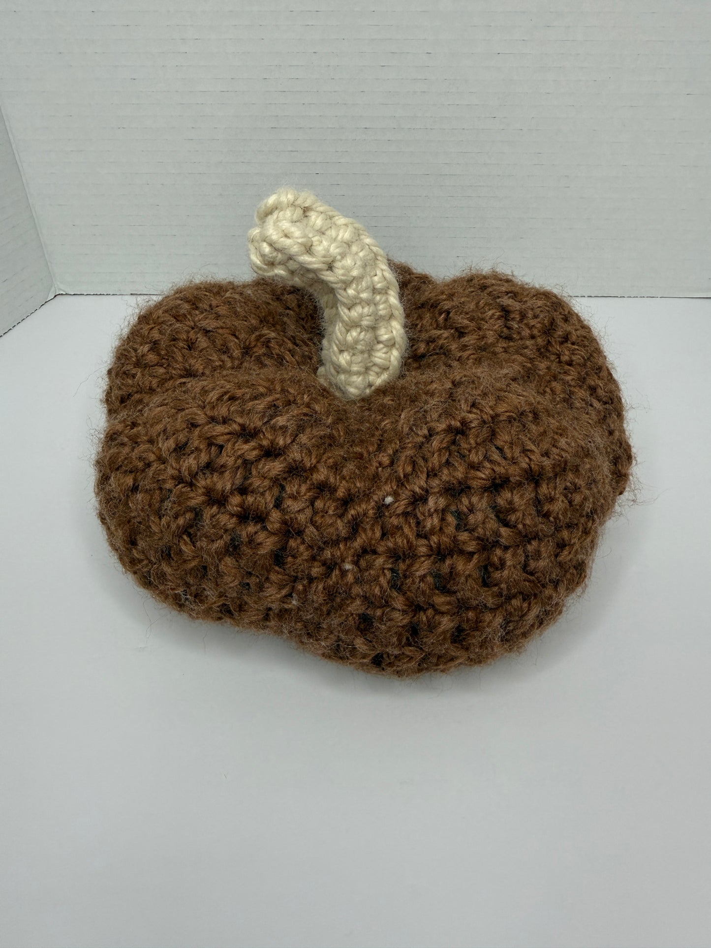 Crochet brown pumpkin on a white background
