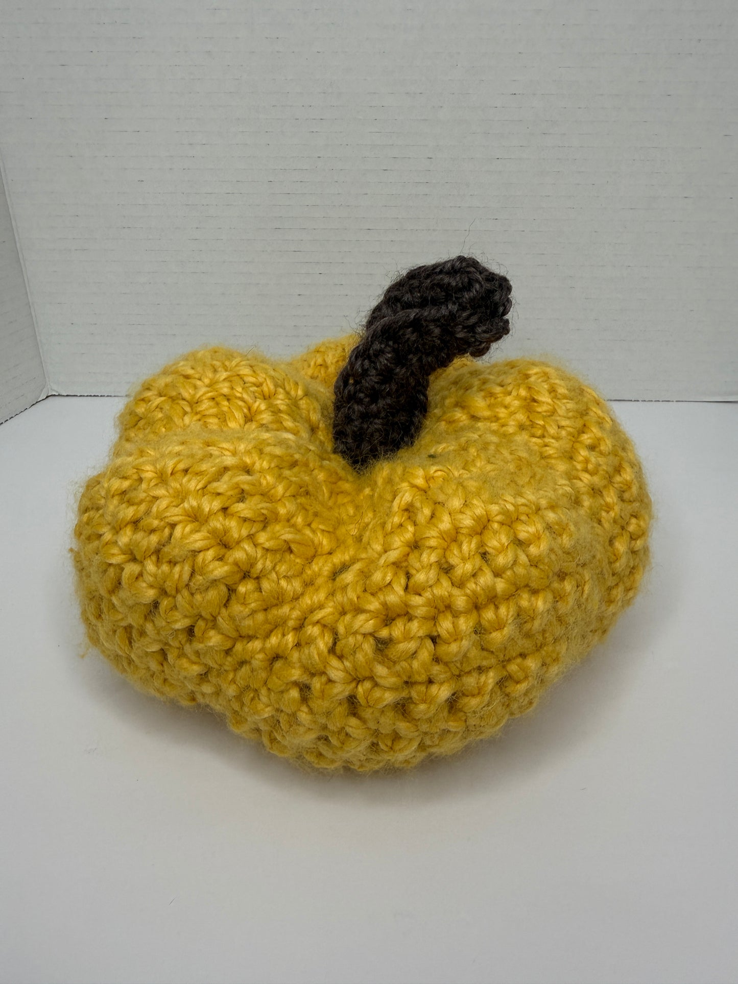 Crochet yellow pumpkin on a white background