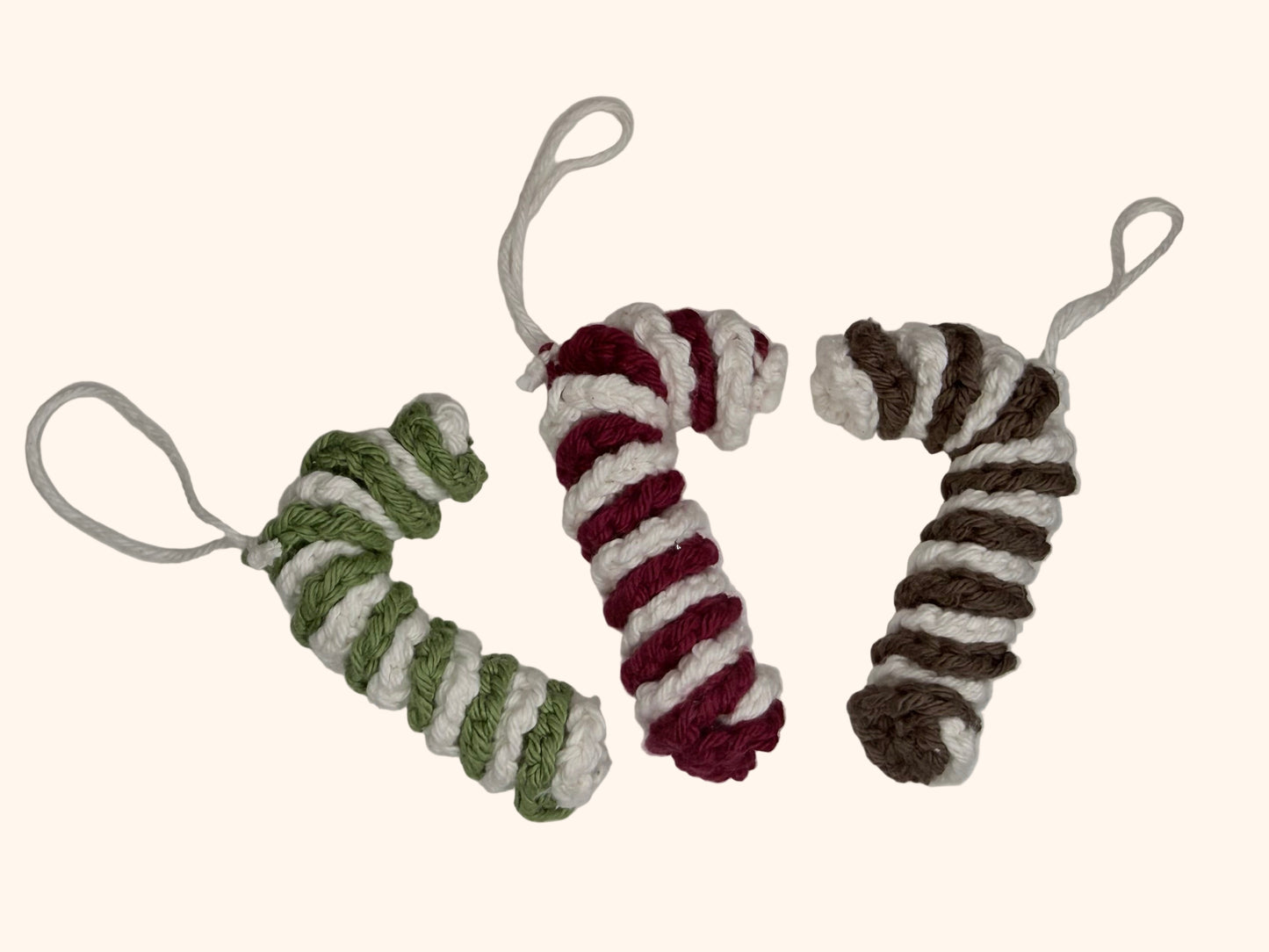 Three crocheted candy canes on a white background