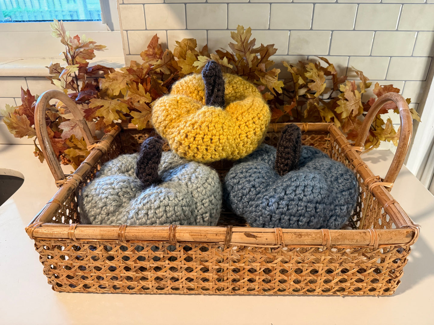 Basket with crochet pumpkins in a kitchen setting